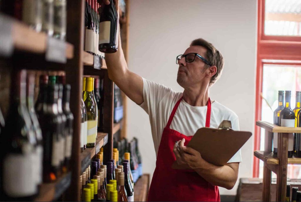Owner of a Wine and Beer Store Taking Inventory Copyright Allen Barron Inc.
